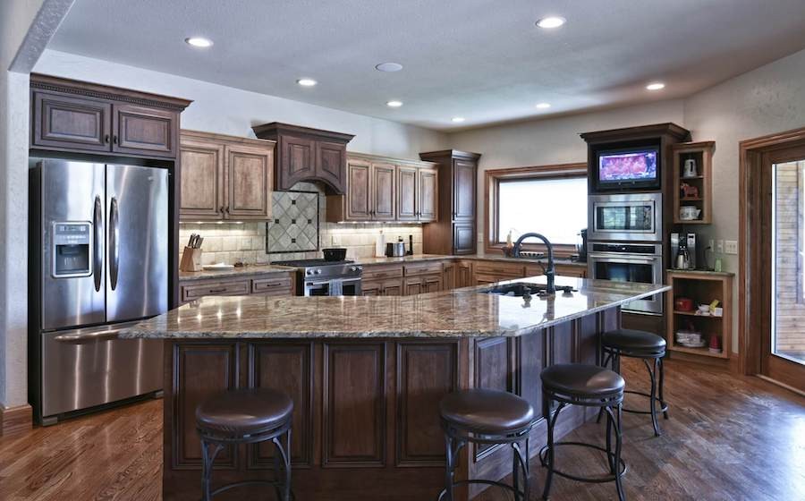 luxury kitchen area with bar, smart lighting, in-ceiling speakers, and a TV