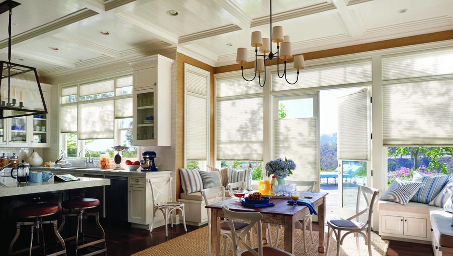 Open-concept kitchen and dining area overlooking floor to ceiling windows with automatic shades