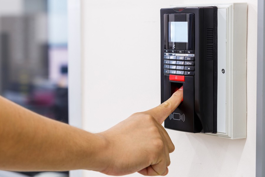 fingerprint reader device with a person’s hand using it.