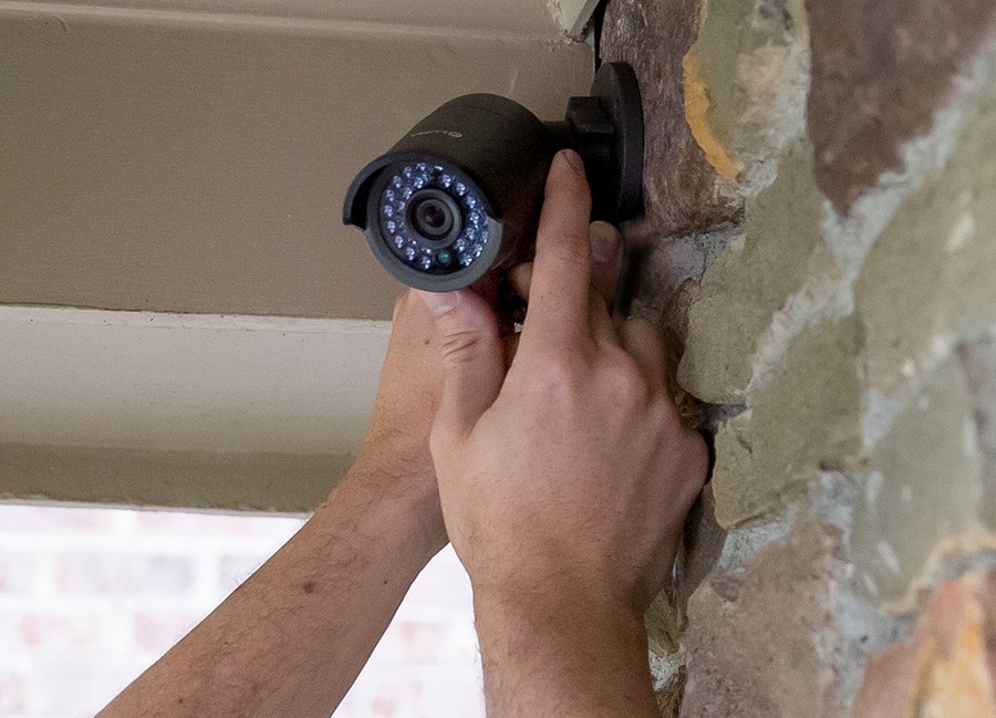 closeup of two hands installing a Luma outdoor security camera