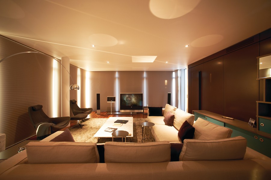 modern home theater space with sectional seating, chairs, and ambient lighting
