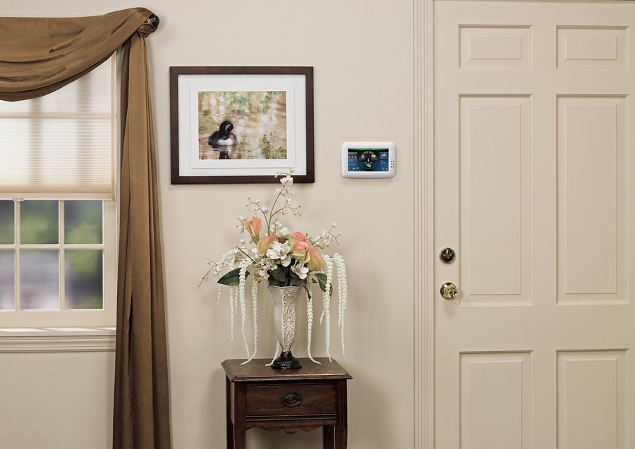 A color screen home security system panel is pictured to the left of the front door in a Kansas home.